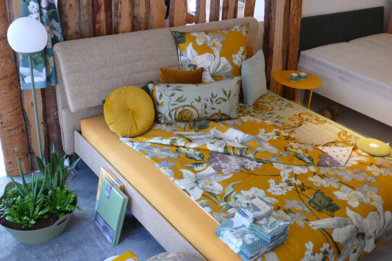 Bettwäsche in einem aktuellen Goldton, passende Spannbetttücher und verschiedene Kissen. Bettgestell von der Firma Möller Design.Beistelltisch von Fermob aus Frankreich.