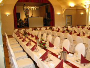 Saal eingedeckt für eine Hochzeit mit 140 Gästen . Stühle mit Hussen.