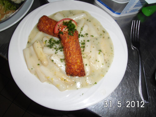 Gefüllte Kartoffeltaschen mit Frischkäse gefüllt auf frischem Spargelgemüse