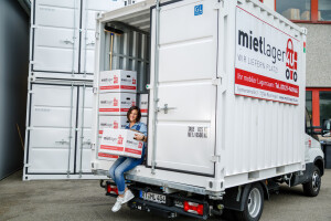 Frau mit Karton im Lagercontainerauf LKW.jpg