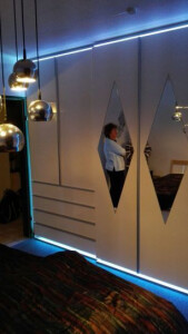 ..Kleiderschrank in weiss Hochglanz mit Griffleisten in Aluminium und ringsum LED Lichttechnik..