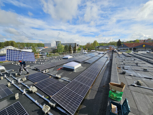 Drohnenansicht einer großen gewerblichen Solaranlage auf einem Flachdach in Weinheim an der Bergstraße.