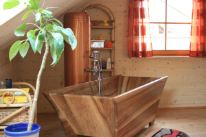 Innenansicht Bad Musterhaus mit außergewöhnlicher Nußbaum-Holz-Badewanne